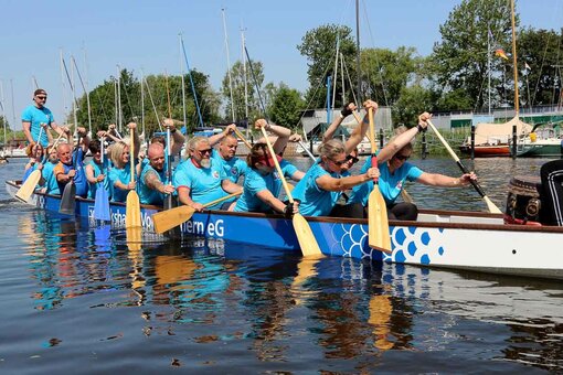 Das Team rudert mit dem Drachenboot